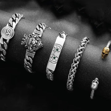 Collection of silver bracelets with various designs on a dark background