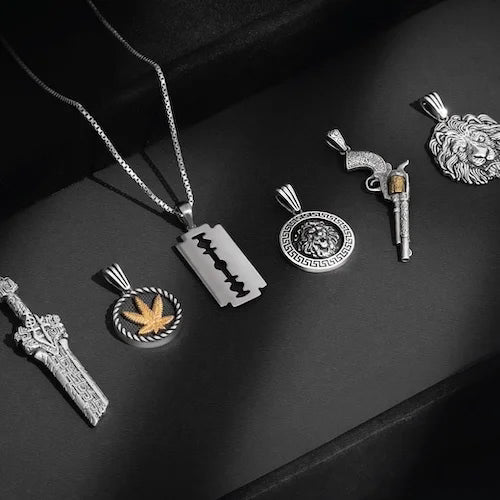 Collection of silver pendants on a dark surface