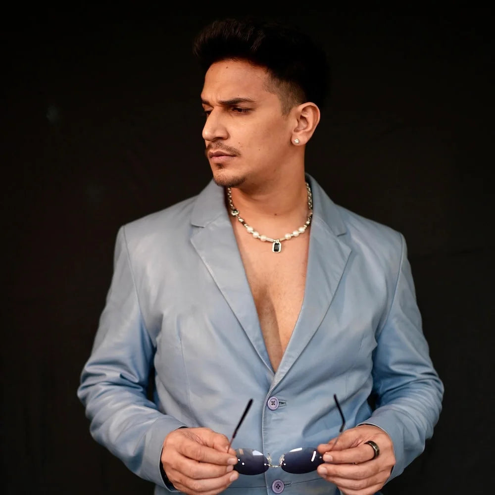 Prince Narula wearing a light blue suit with sunglasses and orionz jewels ear stud