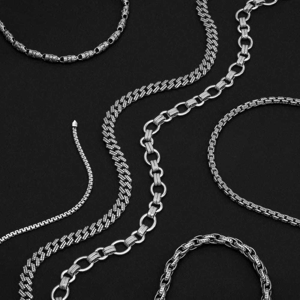 Collection of orionz silver chains on a black background