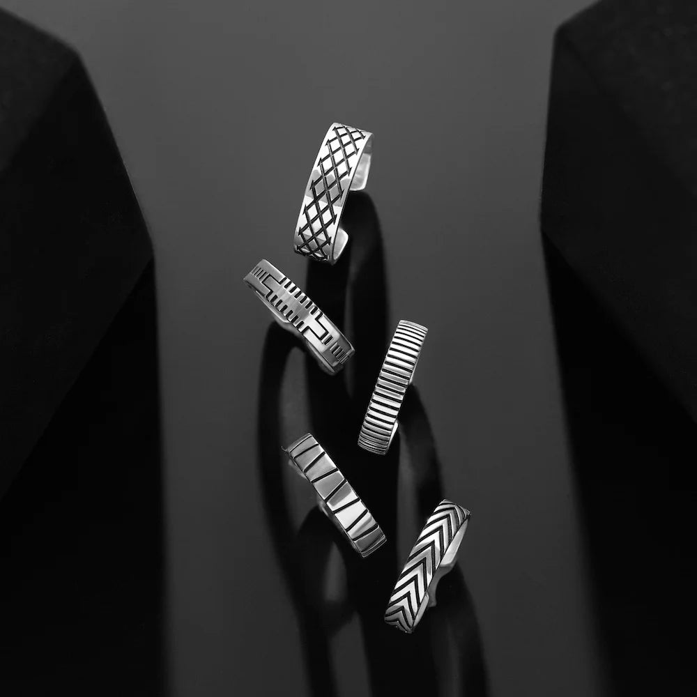 Set of orionz silver earrings with geometric designs on a dark background