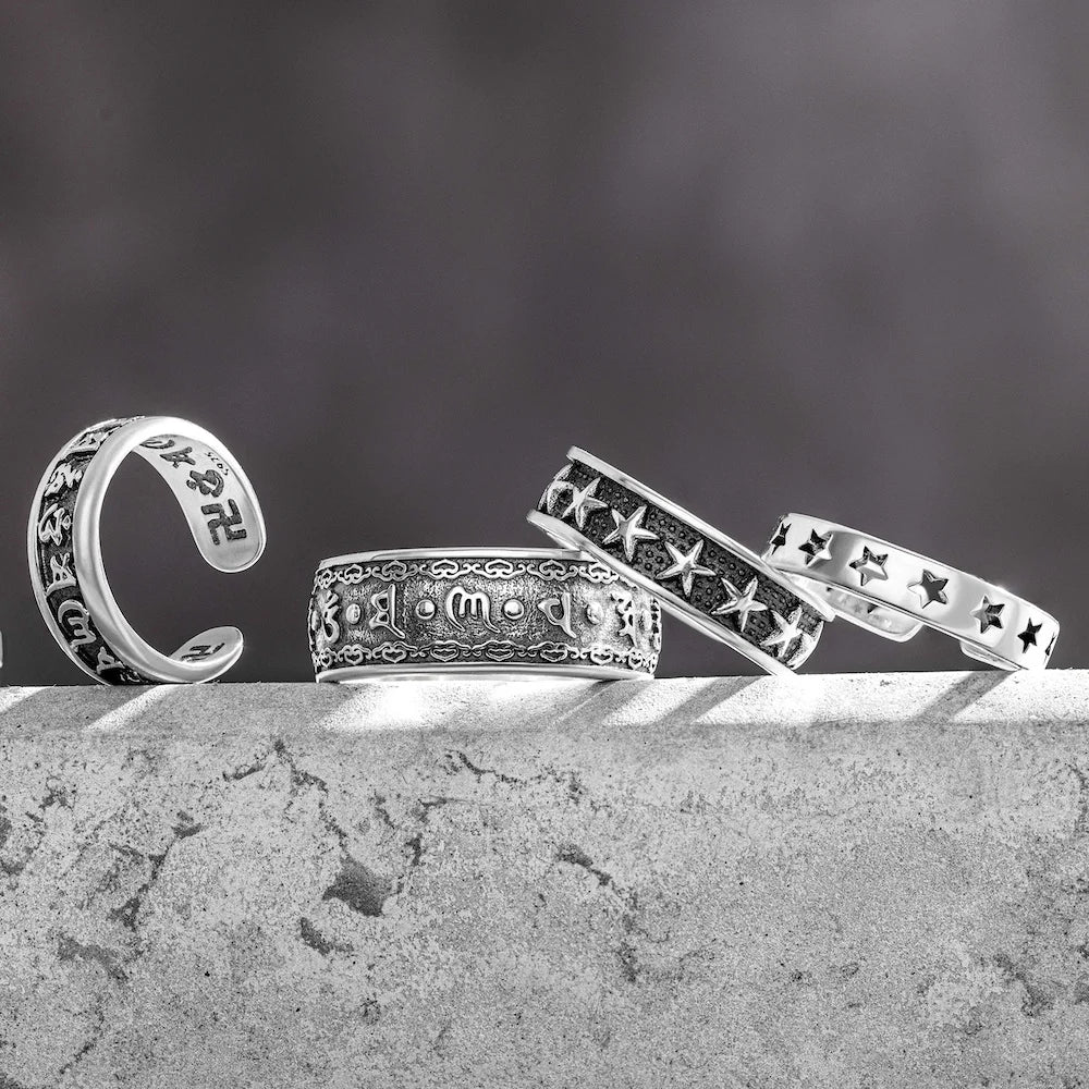 orionz Silver rings with intricate designs on a textured surface