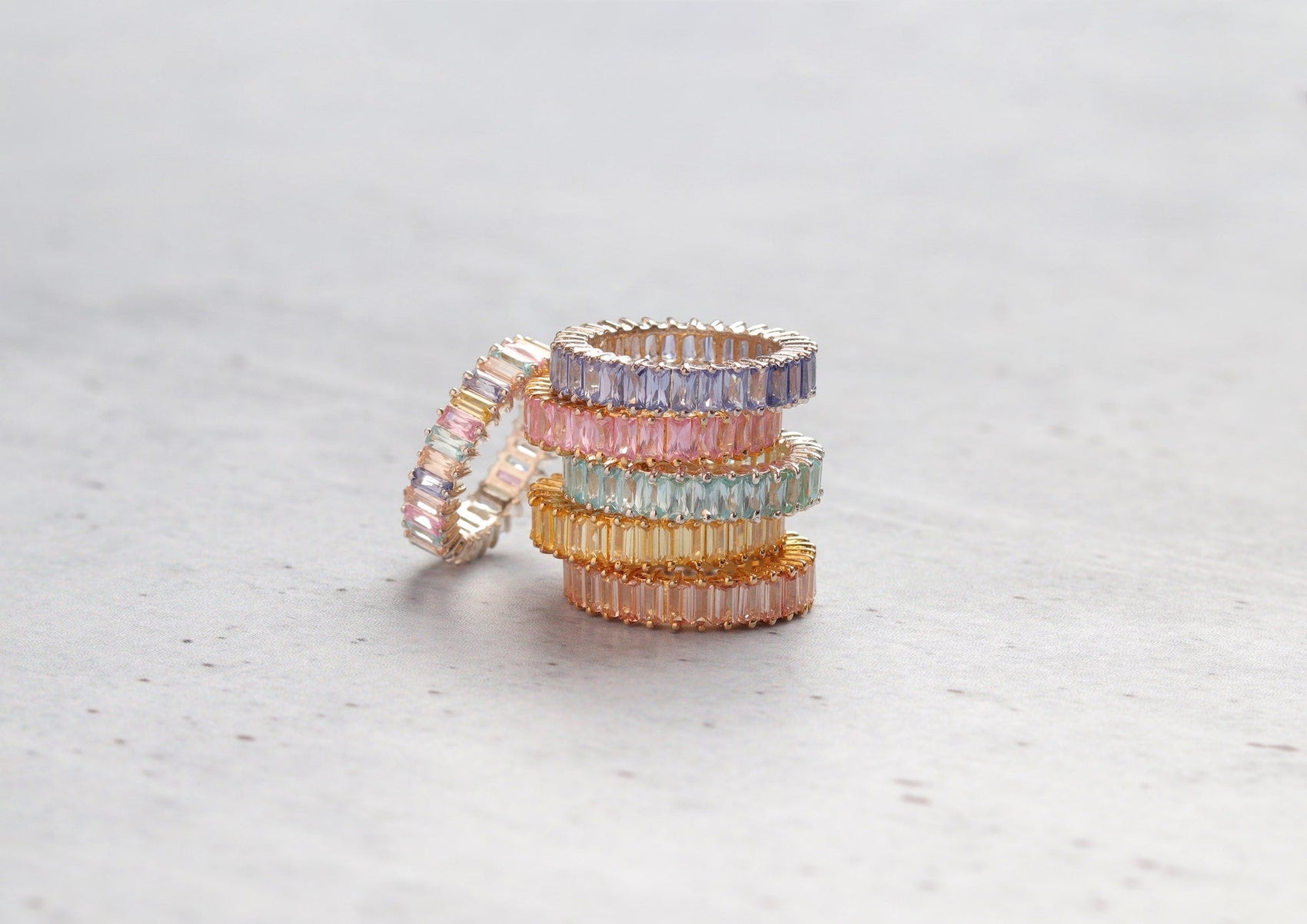 Colorful gemstone stackable rings with pastel pink, purple, blue, and peach hues, ideal for finding gemstones that complement various skin tones.