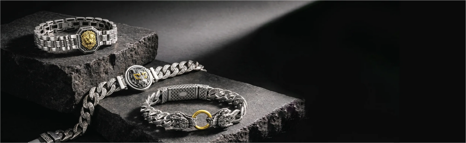 Three silver bracelets with gold accents on a dark surface
