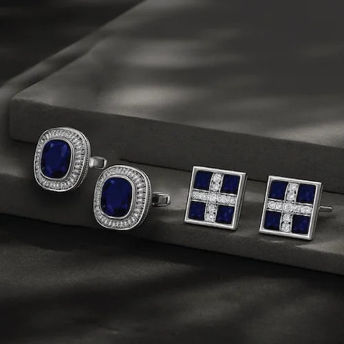 Set of silver cufflinks with blue gemstones on a dark surface