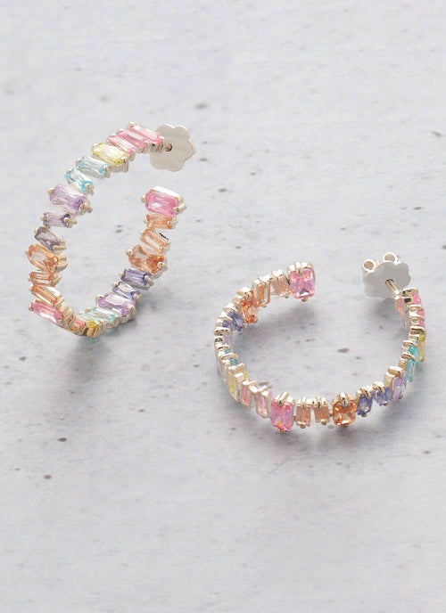 Multicolored orionz hoop earrings on a light gray surface