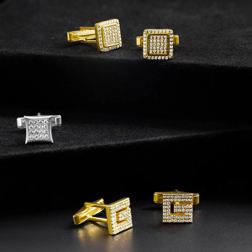 Gold square cufflinks with gemstones on a black background