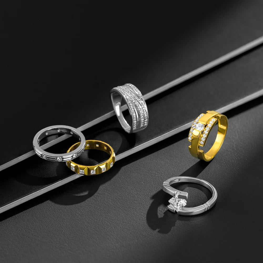 Set of gold and silver rings on a black surface