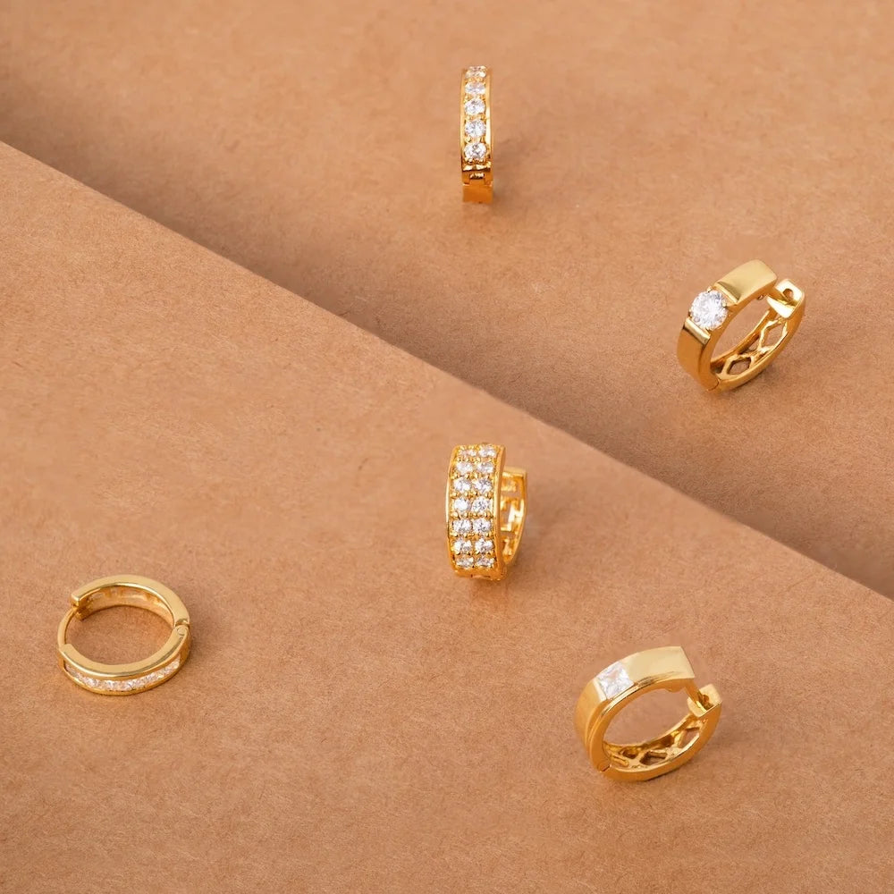 orionz Gold hoop earrings with diamond accents on a brown surface