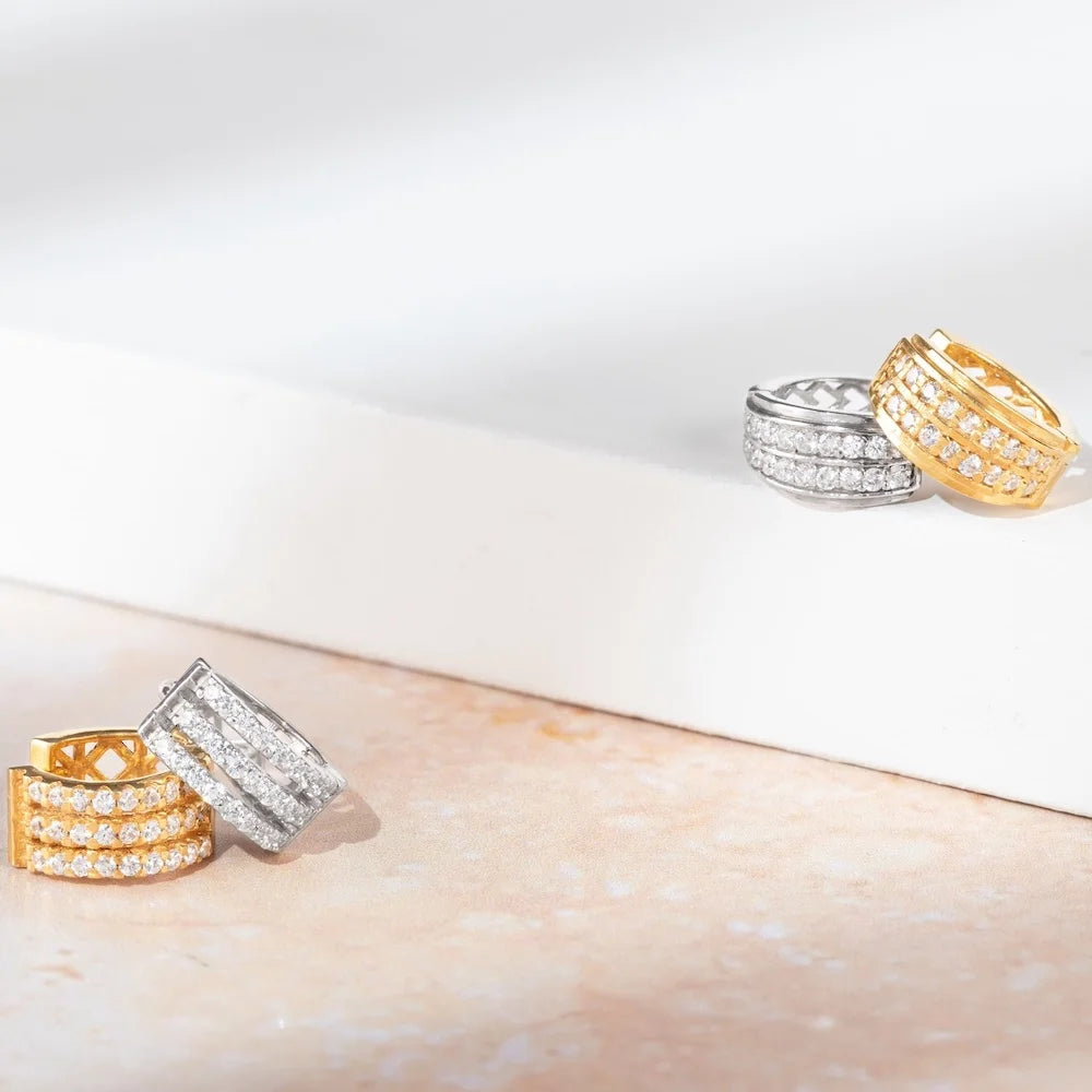 Three orionz diamond rings in gold and silver on a light surface