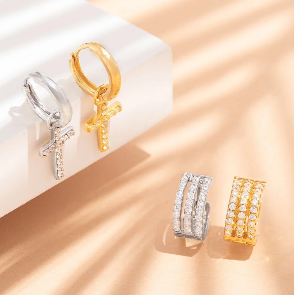 orionz Gold and silver earrings on a beige surface