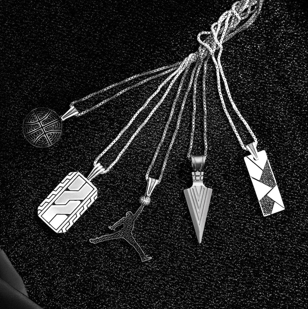 Set of five unique orionz pendants on a black background