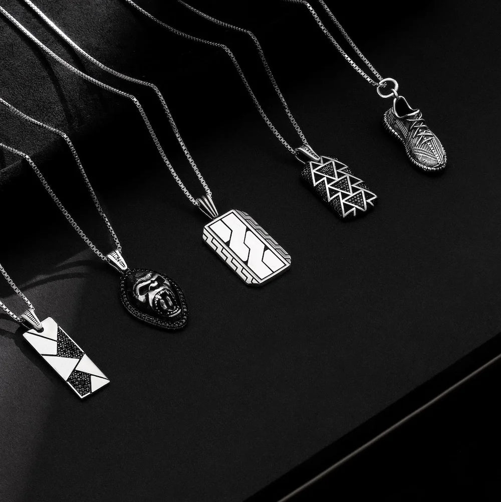 Collection of orionz silver necklaces with various pendants on a black background